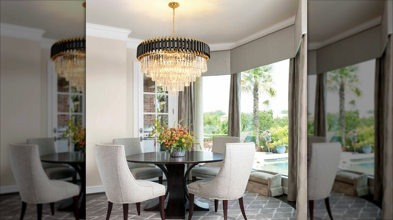 A glass tiered glass crystal chandelier hanging over a dining table
