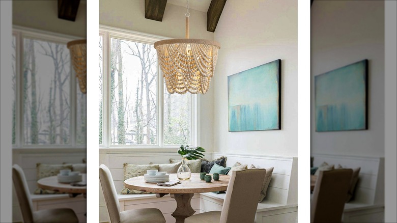 A white beaded chandelier hanging over a dining table
