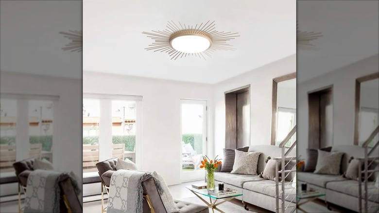 A flush-mount ceiling light with a gold starburst design in a living room