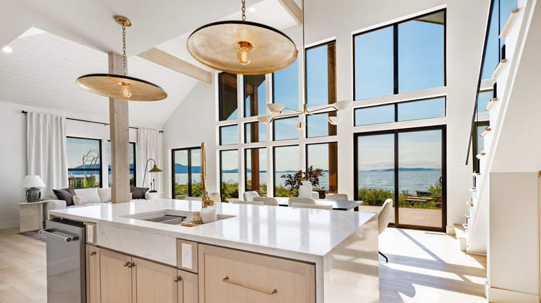 A clean, modern kitchen with two gold light fixtures above island