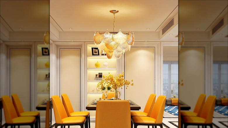 A modern glass chandelier hanging over a dining room table
