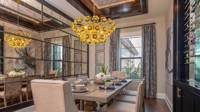 A gold flower chandelier hanging over a dining room table