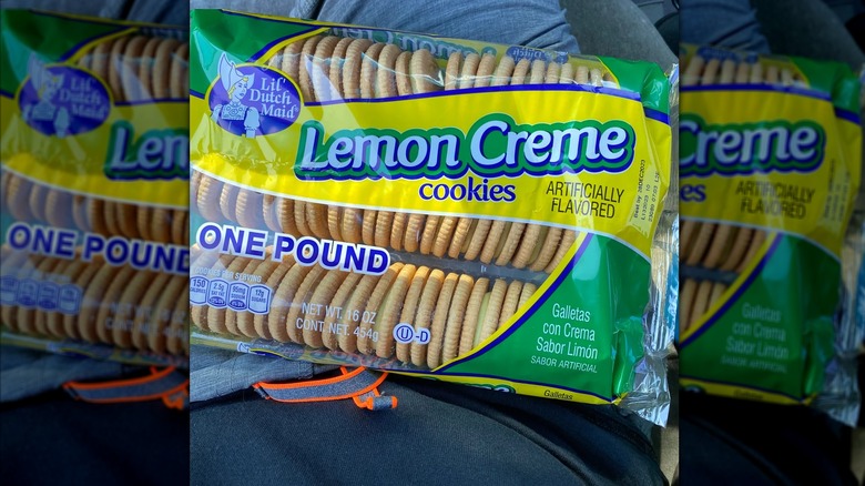 A box of Lil' Dutch Maid Lemon Creme Cookies sits on a person's lap.