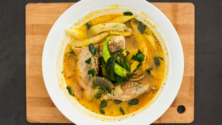 A dish of tinola, a FIlipino soup, prominently featuring green leaves known as malunggay.