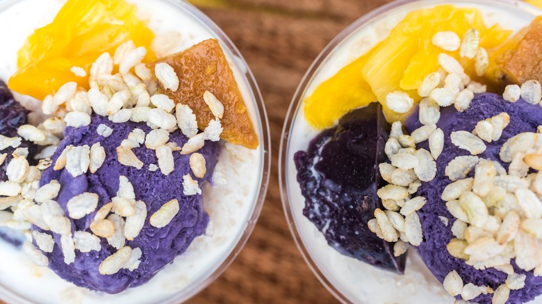 Two bowls of halo-halo, purple shaved ice, topped with grains of toasted rice (pinipig).