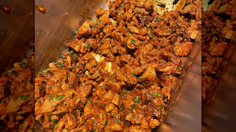 Diced up chicken and sauce in a container