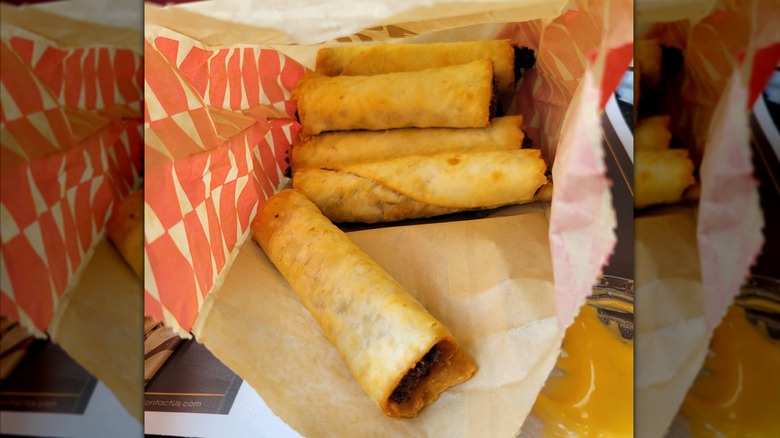 A paper bag filled with Taco John's Mexi Rolls