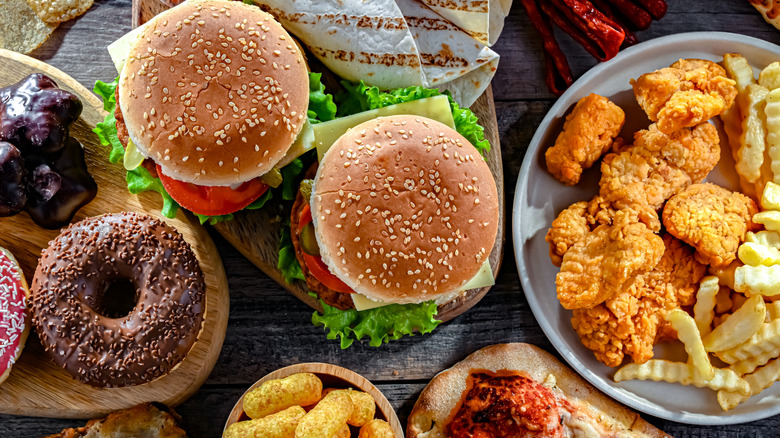 Overhead view of a variety of different fast food items like burgers, chicken nuggets, french fries, and donuts