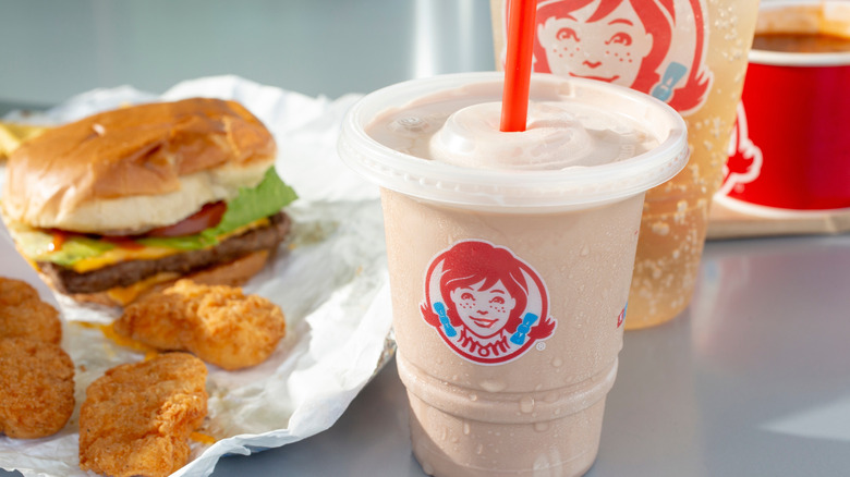 Wendy's Frosty beside chicken nuggets, a burger, and a drink