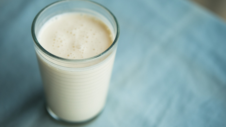 Glass of kefir on blue background