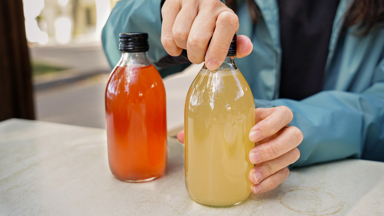 Screwing lid onto bottle of kombucha