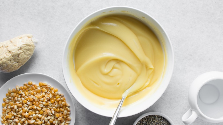 Bowl of Nigerian ogi dessert next to dried corn kernels