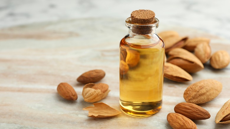 Bottle of almond extract surrounded by almonds