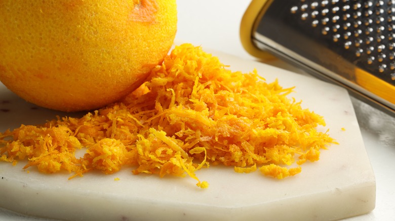 Zested orange on marble cutting board