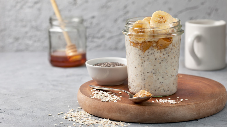Overnight oats in glass jar with peanut butter and sliced banana