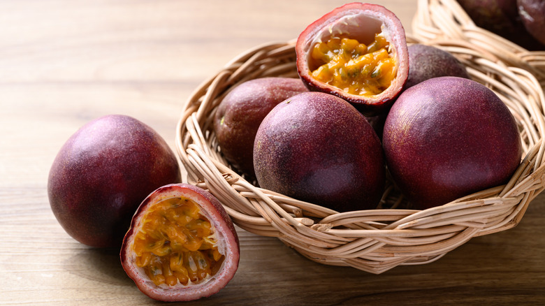Basket of fresh passion fruits with some fruits sliced open