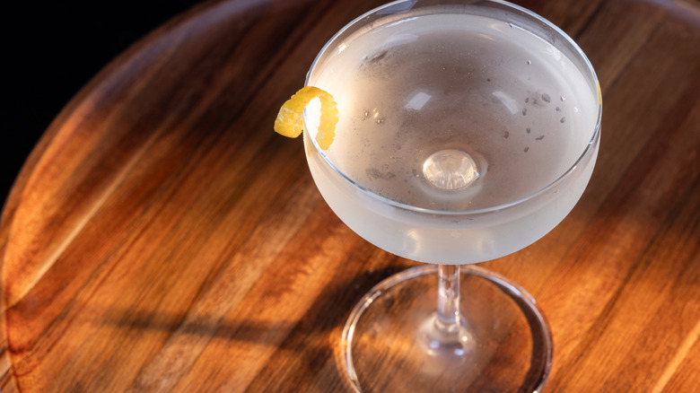 gin martini with a lemon garnish on a wooden table