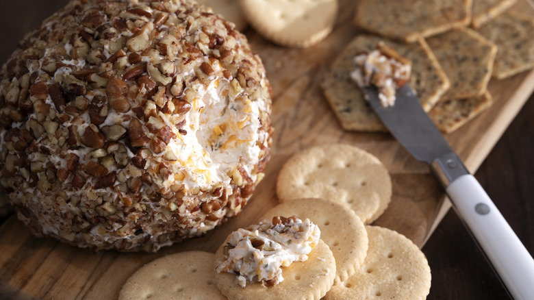 Close-up of a classic cheeseball with crackers on a cutting board with cheese knife