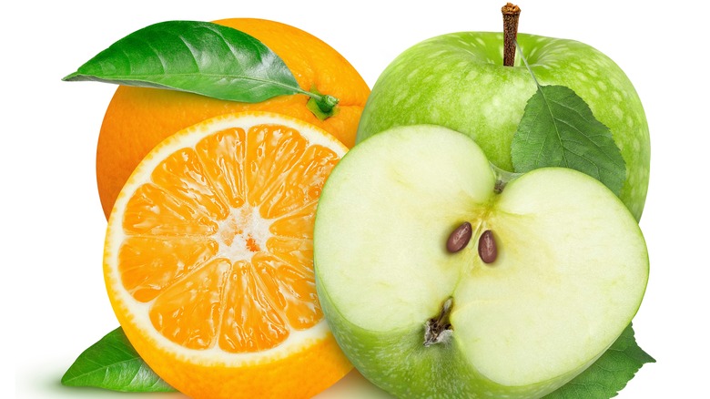 Close up of apples and oranges with a white background