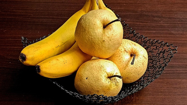 Bananas and pears in a black wire basket
