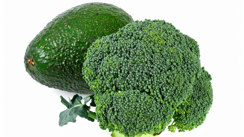 Close up of broccoli and avocado on a white background