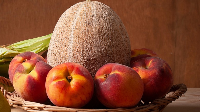 Melon and peaches in a wooden basket