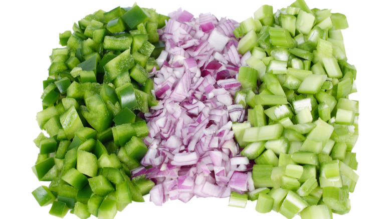 Three piles of diced green sweet bell pepper, red onion, and celery in rows