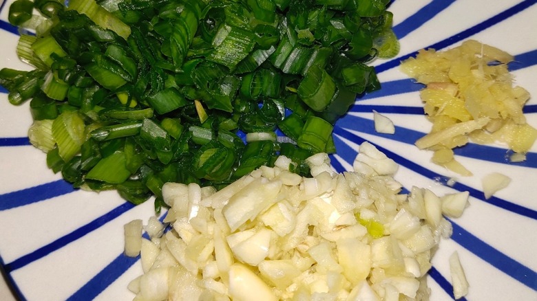 Chopped garlic, scallions, and ginger on a plate