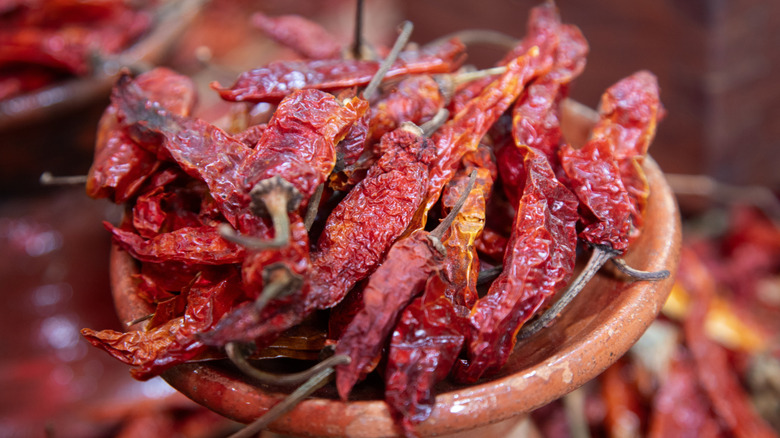 A clay pot containing dried red chile peppers