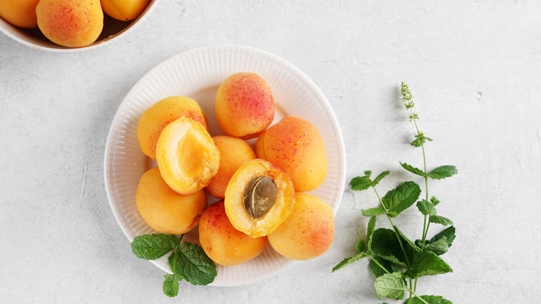 Bowl of whole and half fresh apricots