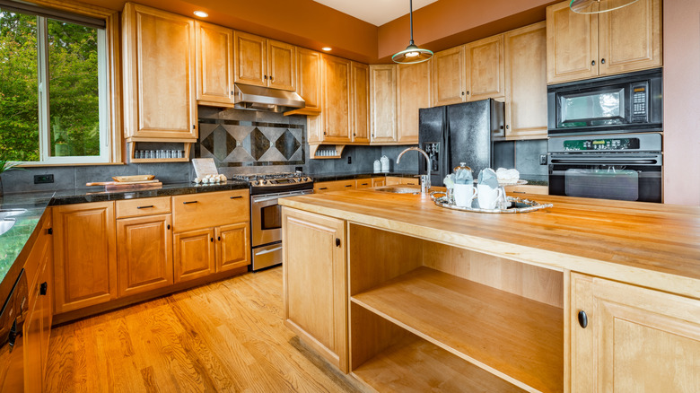 A cozy kitchen with warm, golden wood cabinets and a butcher block kitchen island