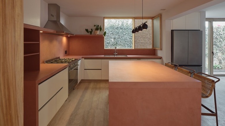 A modern, open kitchen with custom Dekton counters, backsplash, and island in a deep umber color