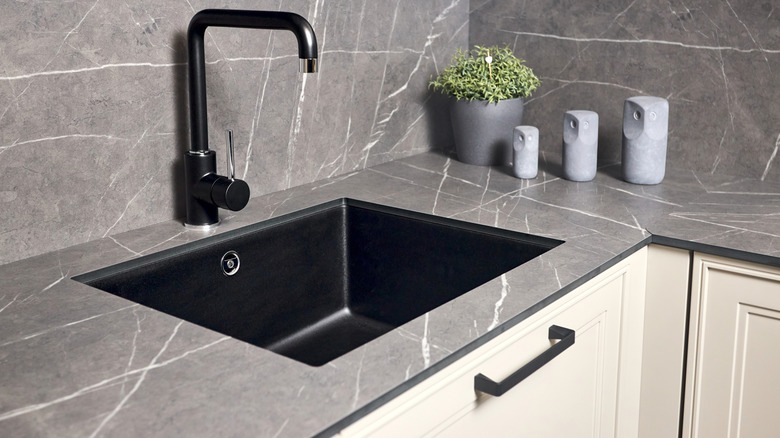 Kitchen sink, backsplash, and countertop with a dark gray faux-marble design
