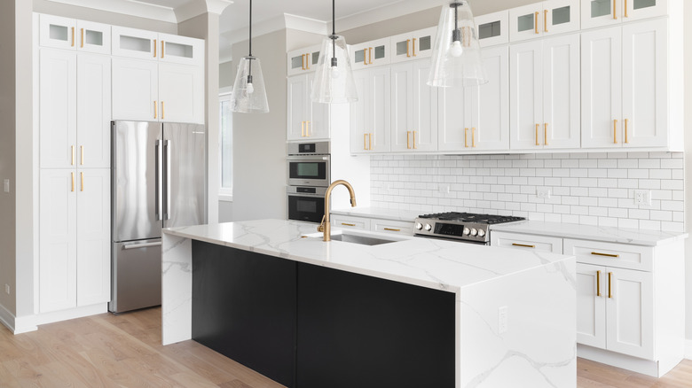 A modern kitchen with a white quartz waterfall countertop