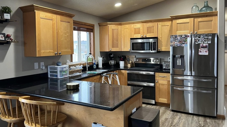 A kitchen with Black Galaxy granite counters and pale golden oak cabinetry