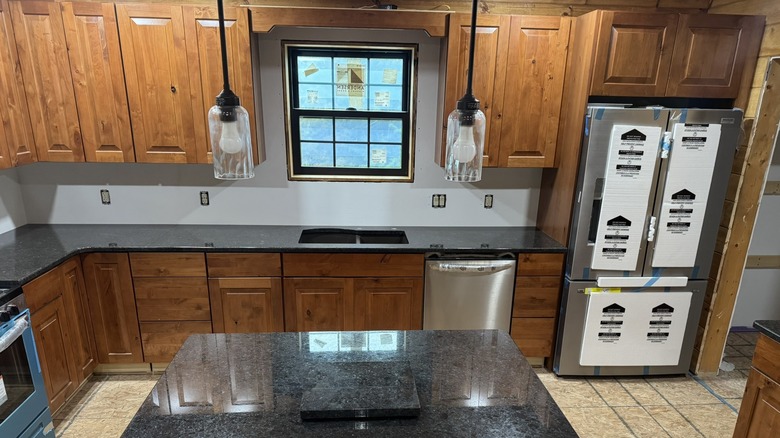 A kitchen featuring Coffee Brown granite countertops paired with warm maple cabinetry