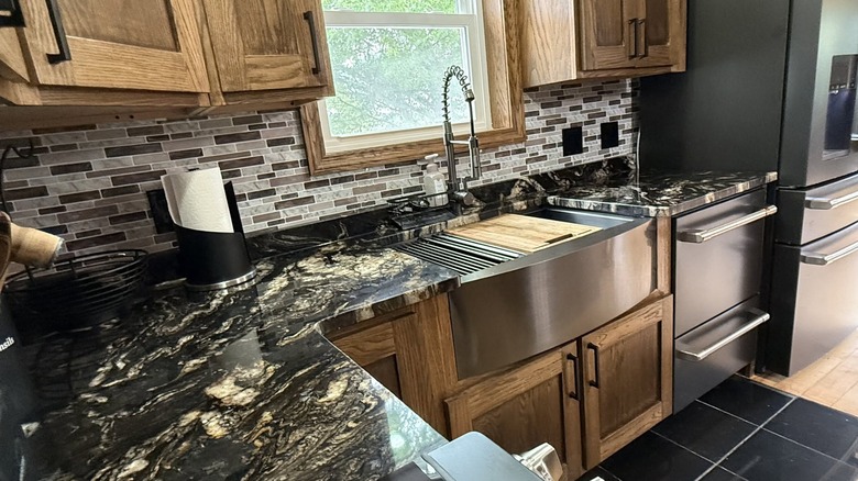 Titanium granite countertops installed in a kitchen with rustic maple cabinets