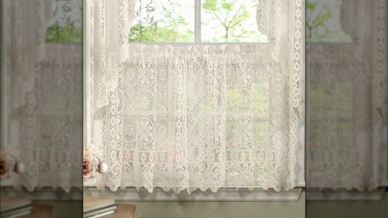 Lace cafe curtains hung in a window