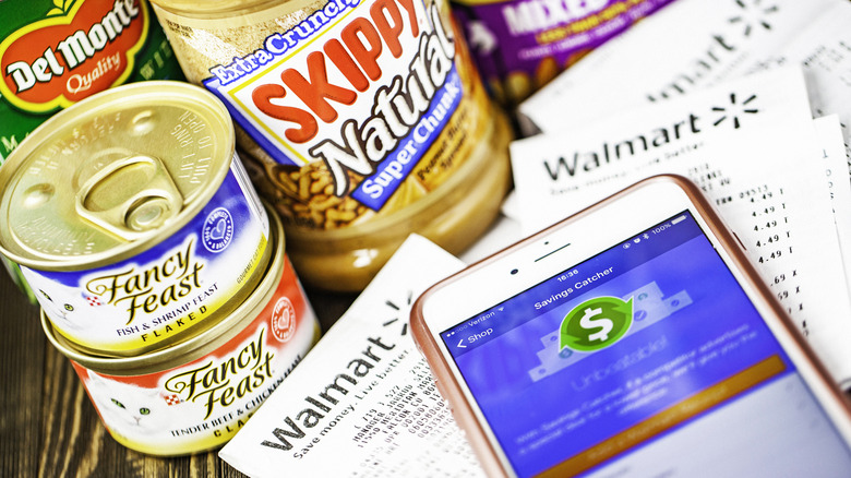 An array of groceries on a countertop with a receipt and cell phone nearby