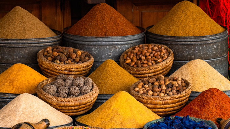 A Moroccan spice market with spices piled high in pyramid shapes