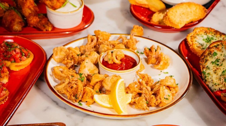 plate of calamari with lemon wedges and dipping sauce