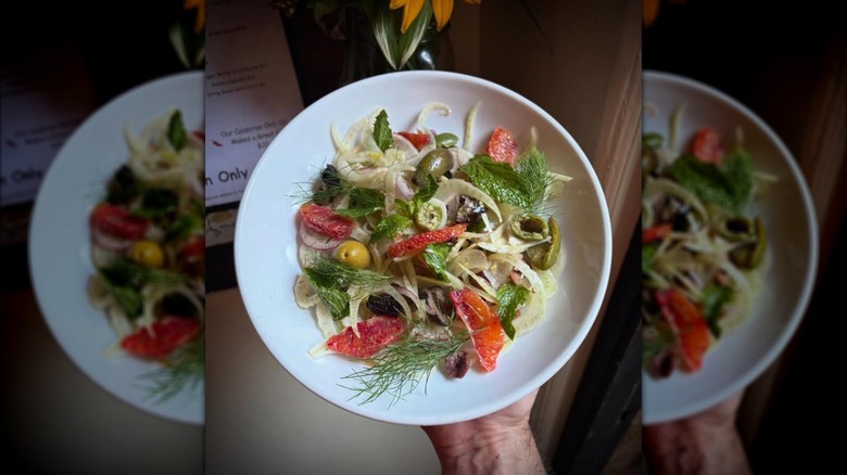 A Scicilian salad with blood orange, fennel, and dill in a white bowl