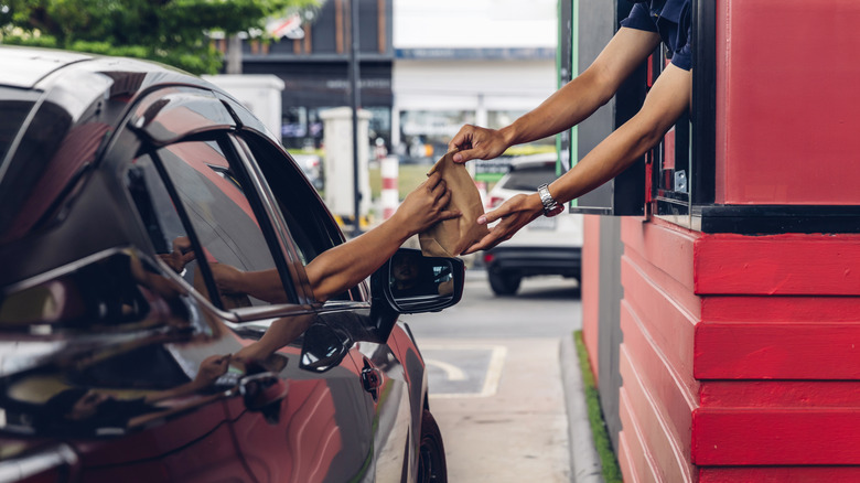 employee passing driver fast food