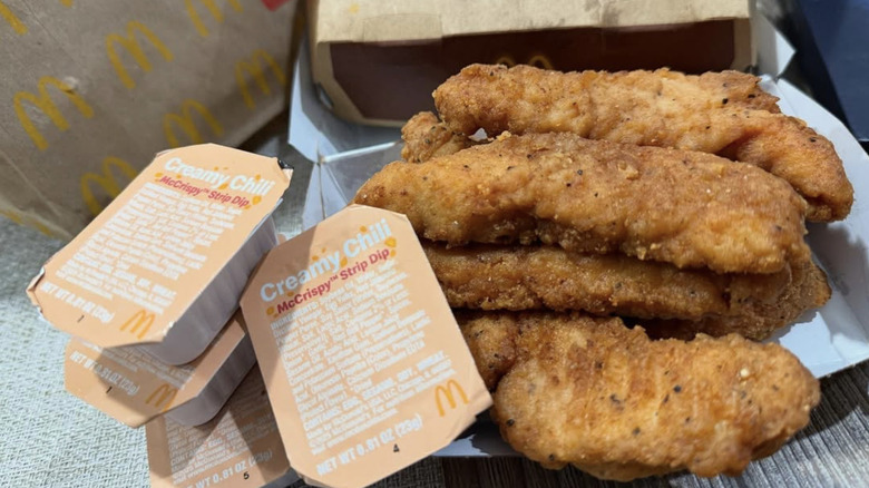 close up of McDonald's 3 Piece McCrispy Strips and Creamy Chili dipping sauce packets