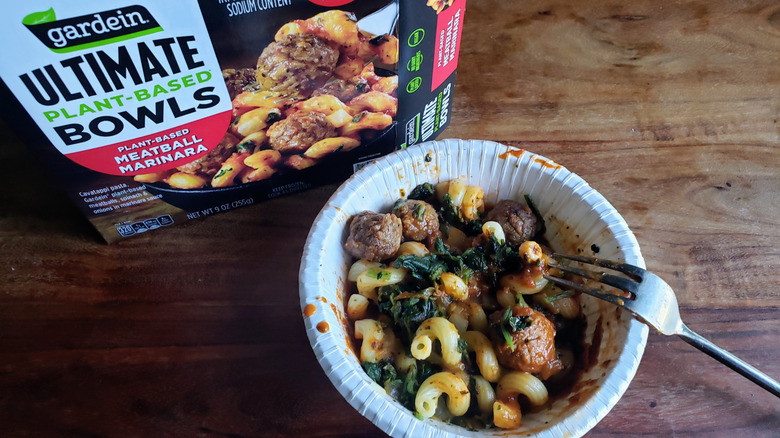 Bowl of Gardein Plant-Based Meatball Marinara on wooden table with fork