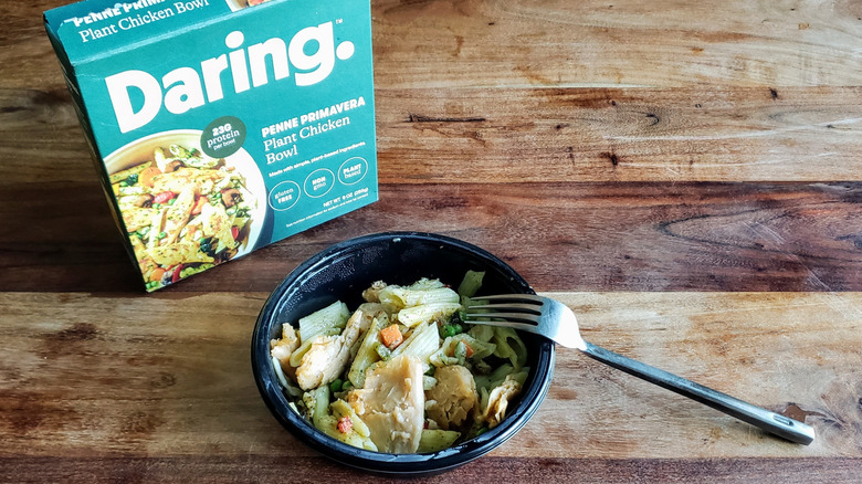 Daring Penne Primavera Plant Chicken Bowl on a wooden table with fork