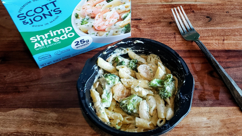 Bowl of Scott & Jon's Shrimp Alfredo on wooden table with fork