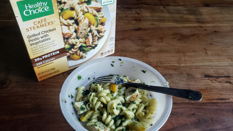Bowl of Healthy Choice Café Steamers Grilled Chicken Pesto with Vegetables on a wooden table with fork