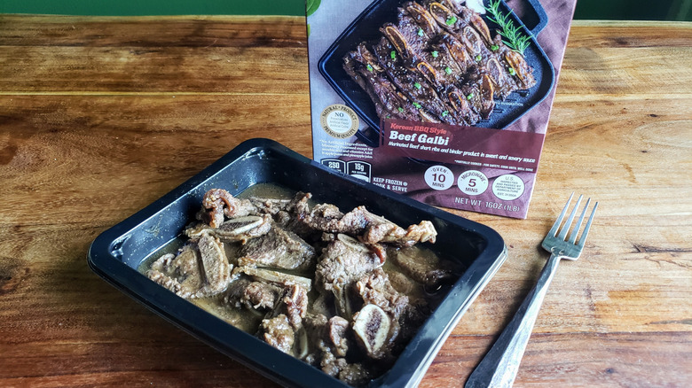 Container of PK Korean BBQ Style Beef Galbi on wooden table with fork