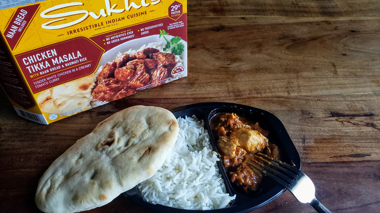 Container of Sukhi's Chicken Tikka Masala on a wooden table with fork